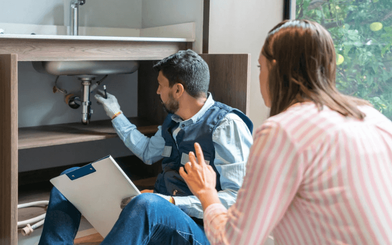 Professional Plumber Fixing Kitchen Sink Leak