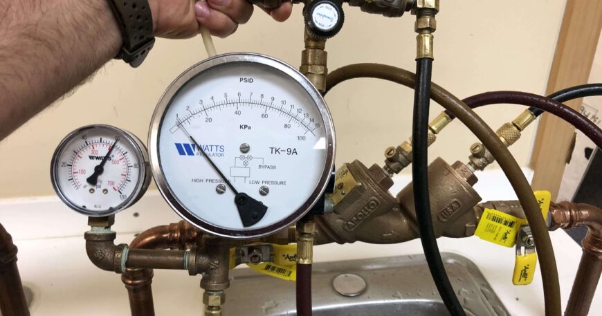 Plumber testing residential backflow prevention device