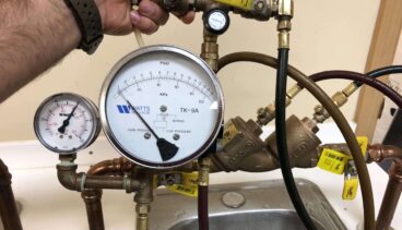 Plumber testing residential backflow prevention device